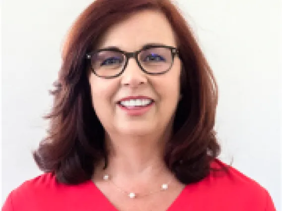 Lupita, smiling Latina woman with shoulder length dark hair, wearing a red top and glasses