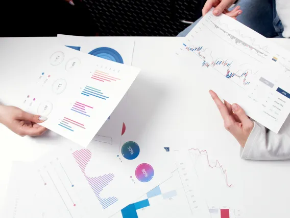 Persons Holding Printer Papers with Graphs