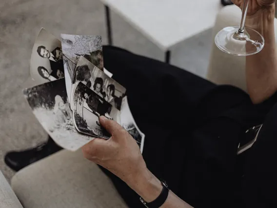 Person Holding Photographs While Sitting on the Sofa