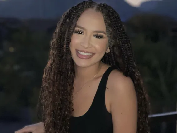 Jocelyn, smiling woman with long dark curly braids