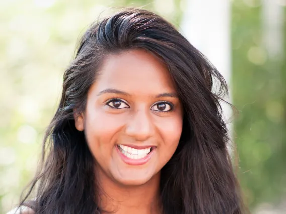 Shivani, a long dark wavy hair woman smiling