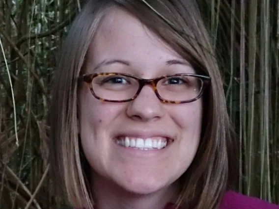 Woman with short hair and glasses smiling