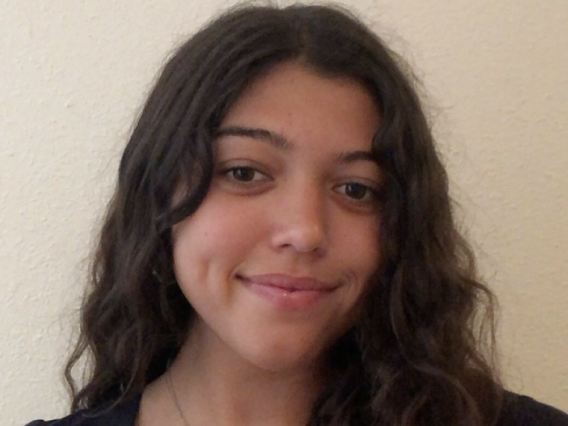 Bi-racial girl with long dark curly hair wearing a black v-neck t-shirt