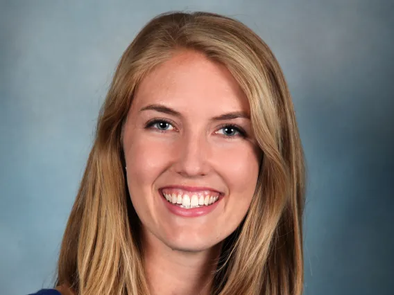 A Blonde woman with blue top smiling 