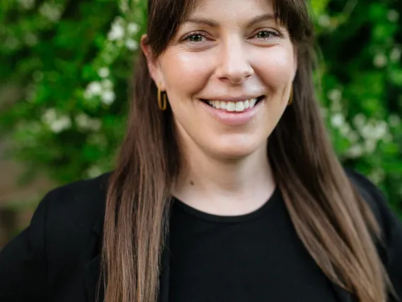Woman with long light brown hair wearing a black top