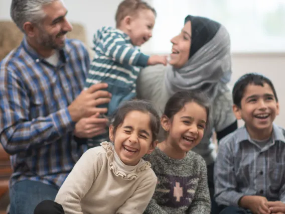 Refugee family smiling and posing for photo.