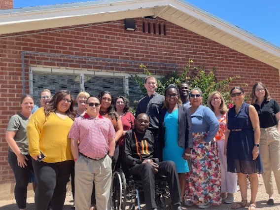 Denis Ouma and Sonoran Center staff standing outside in front of a building on a sunny day