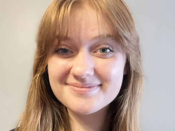 Headshot of Kate Larsen, a white woman with strawberry blonde hair and green eyes.