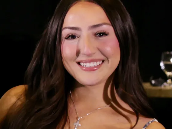 A woman with long brown hair smiling at the camera