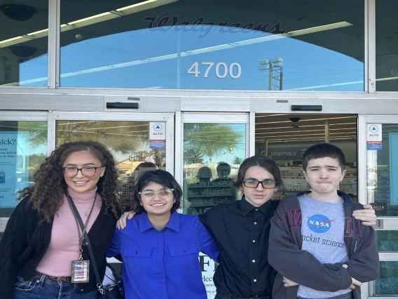 4 youth standing in front of store front