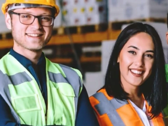 two construction workers a male and female standing and smiling.