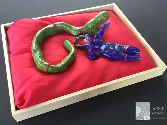clay figures of snake and person