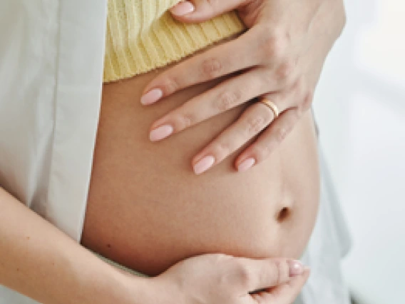 Photo of woman holding her pregnant belly