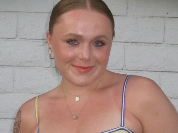 Kendall Smith, a young person with fair skin and light brown hair in a yellow top, smiling
