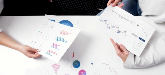 Persons Holding Printer Papers with Graphs