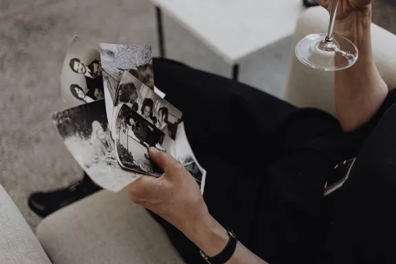 Person Holding Photographs While Sitting on the Sofa