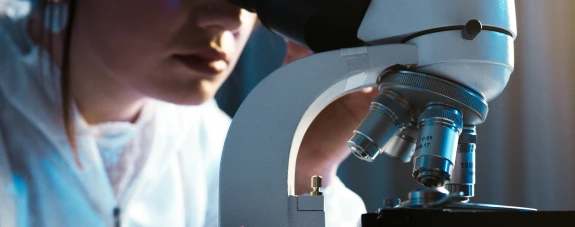 A healthcare worker looking through the microscope