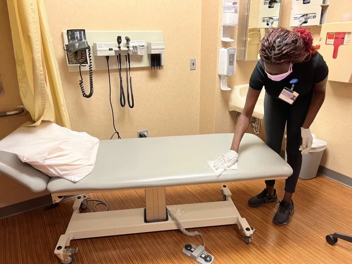 Project SEARCH intern cleaning exam table during their rotation at Mayo Clinic.