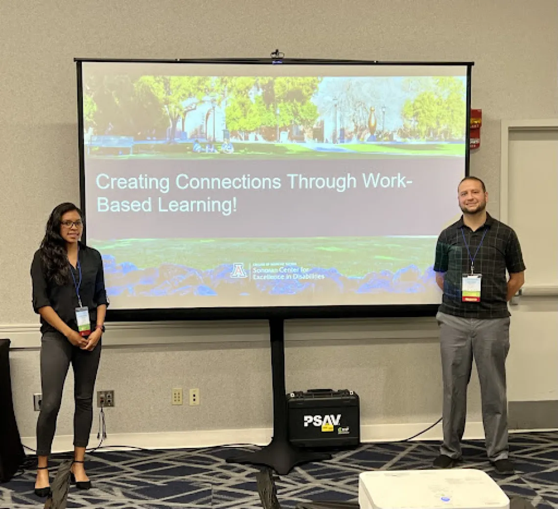 Man and woman standing in front of a presentation screen