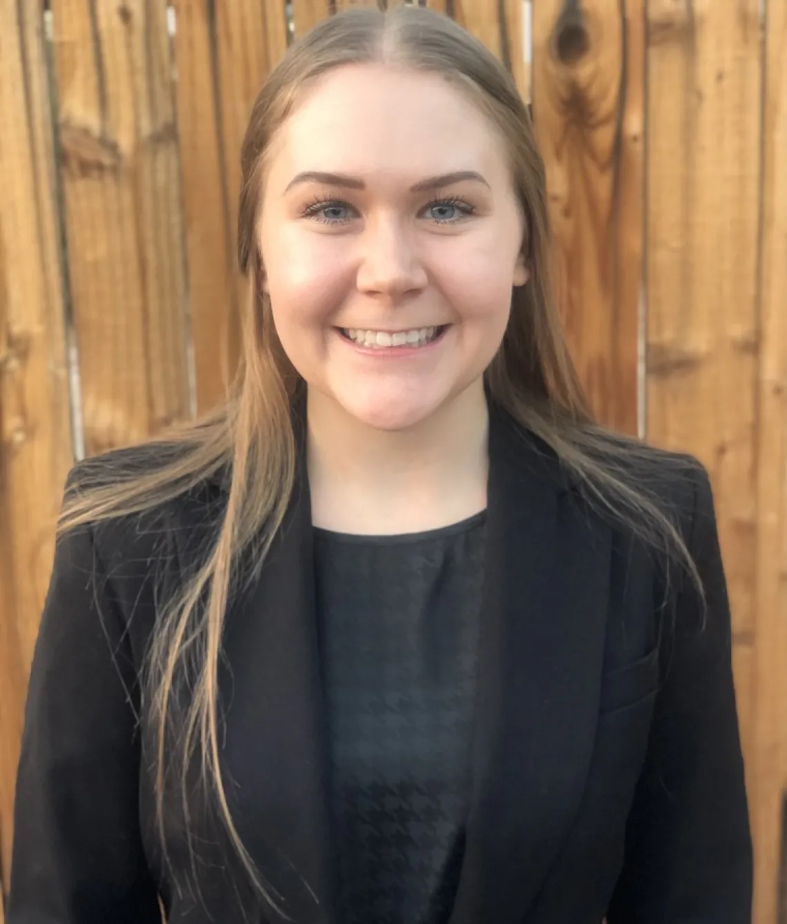 Alyssa Gandolph, a white woman with brown hair wearing a black blazer and gray blouse