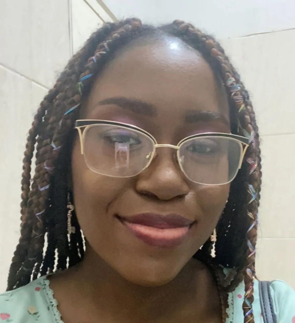 Sylvia Badger, a young woman with braided hair, wearing a blue top, with a slight smile