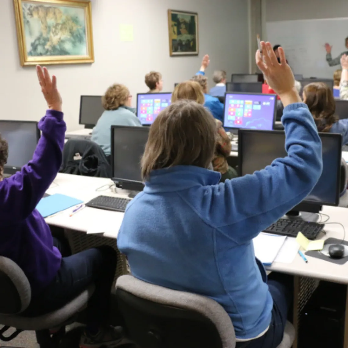 Group of people sitting in a training session in an office setting.