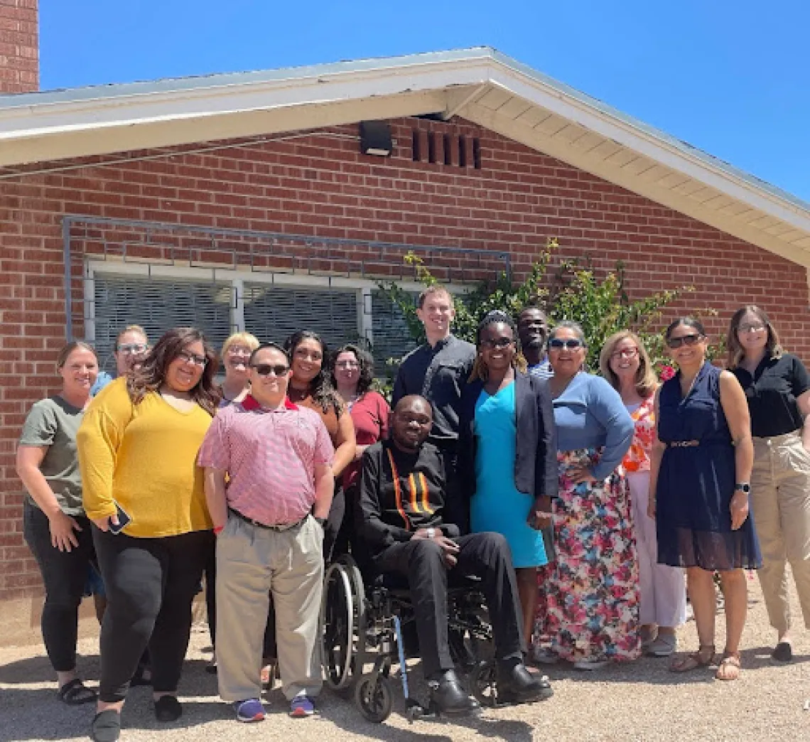 Denis Ouma and Sonoran Center staff standing outside in front of a building on a sunny day