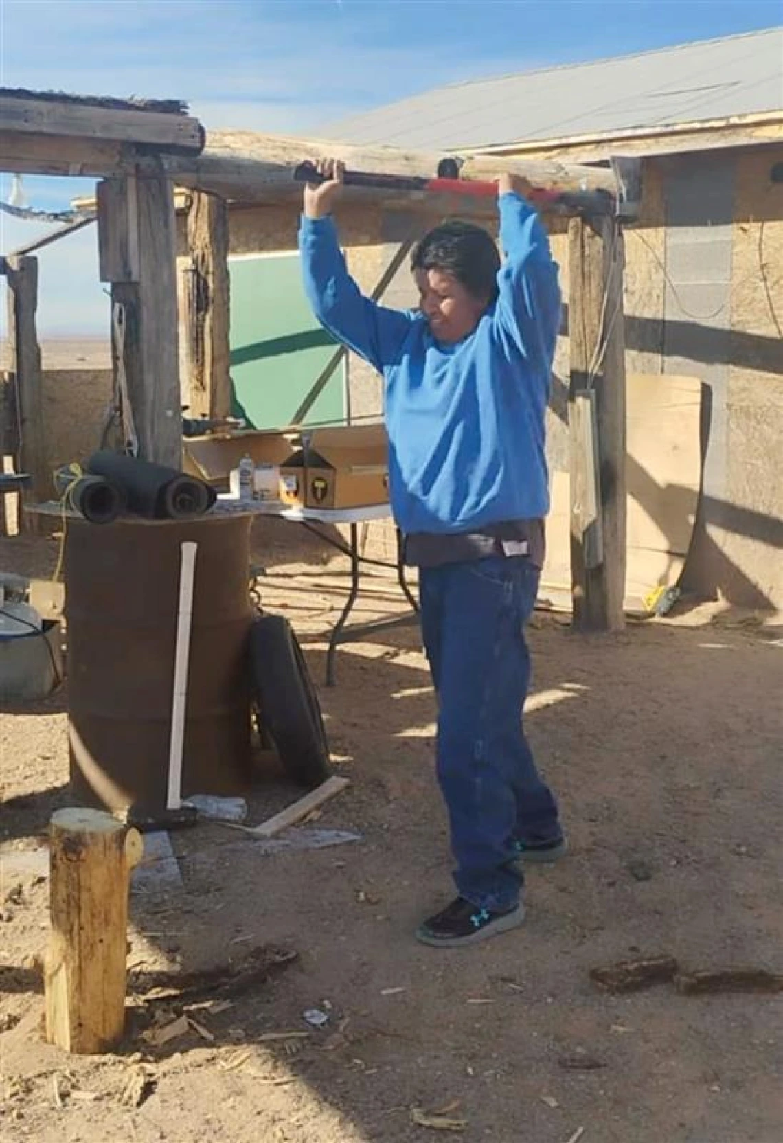 A person chopping wood outside, swinging an axe