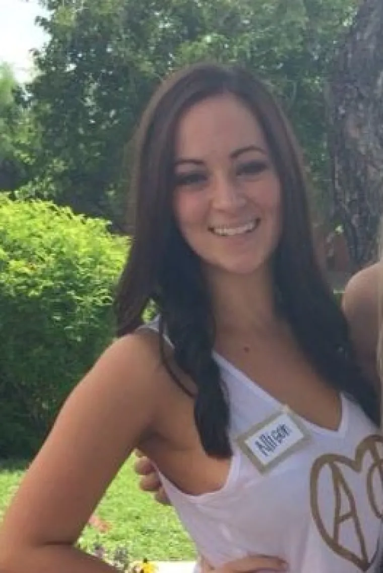 Woman with long hair in tank top smiling