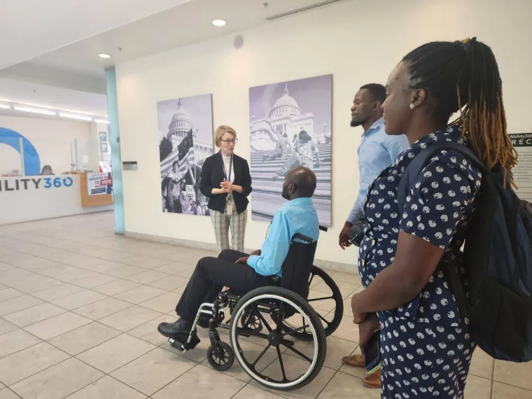 Denis visits Ability 360, a center for independent living, in Phoenix. An ability 360 member guides Denis, who is on his wheelchair, as well as his support staff behind him, through the interior of Ability360.