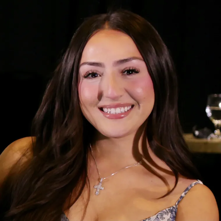 A woman with long brown hair smiling at the camera