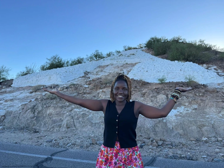 Mai smiles and poses  in front of ‘A’ Mountain A.