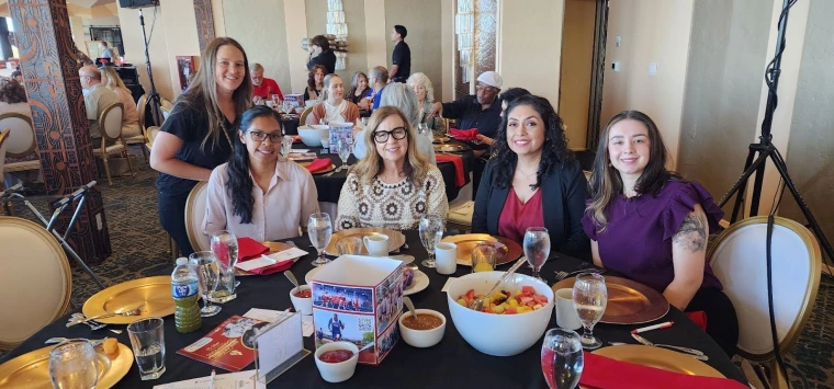 Sonoran Center staff sit at a table for breakfast at the Breakfast With Champions
