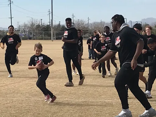 A football team playing with a boy at SuperFest