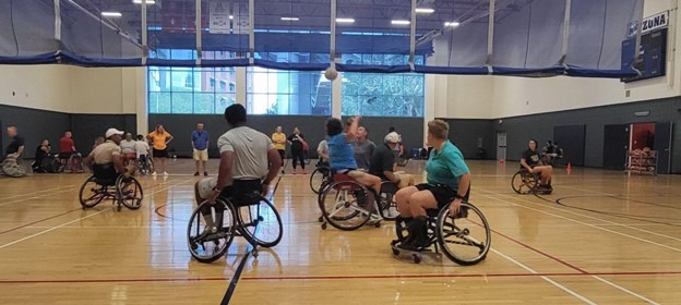 Physical Education faculty from around Tucson trying out the sport wheelchairs via a game of Sharks & Minnows