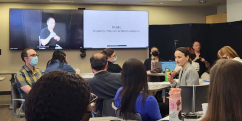 Group of people in a conference room sitting at tables and engaging in conversation