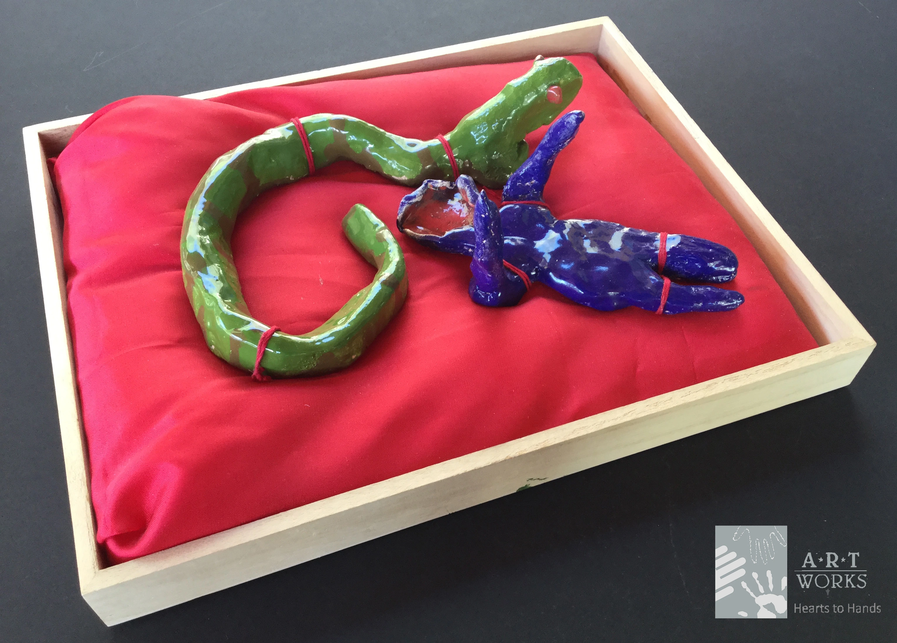 clay figures of snake and person