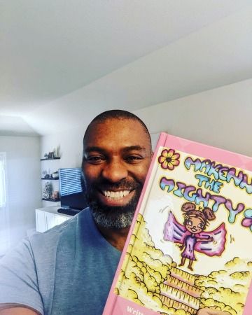 A man taking a selfie with the Makenna the Mighty book