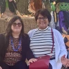 Francine and her mother, Maria, sitting outside on a hay bale surrounded by Halloween decorations
