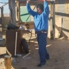 A person chopping wood outside, swinging an axe