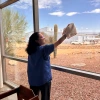 A WBLP participant smiles as she cleans the windows at the Pima Air and Space Museum