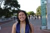 Cosette Tsai, a person with long brown hair, smiling, outside, wearing a floral top with blue and yellow graduation cords